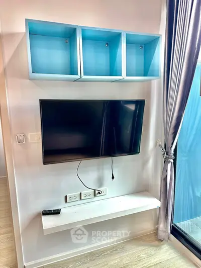 Modern living room with wall-mounted TV and stylish blue shelves