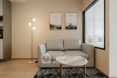Modern living room with cozy sofa, stylish decor, and natural light through large window.