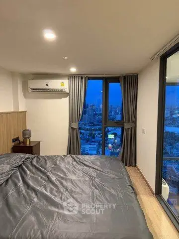 Modern bedroom with city view and sleek design in high-rise apartment.