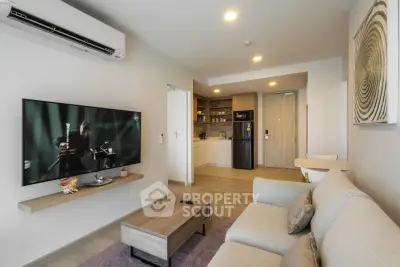 Modern living room with open kitchen, featuring sleek furniture and contemporary decor.