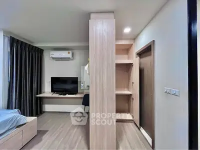 Modern bedroom with sleek design, featuring a TV, air conditioning, and stylish furniture.