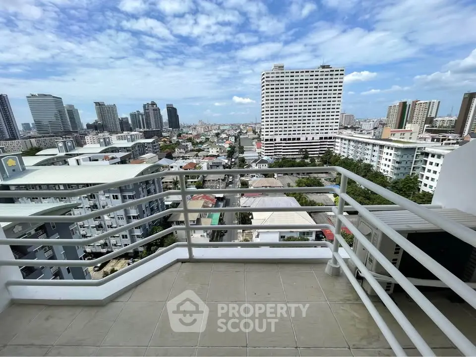 Stunning cityscape view from a spacious balcony in a high-rise building.