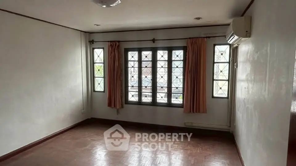 Spacious empty room with large windows and air conditioning, perfect for customization.