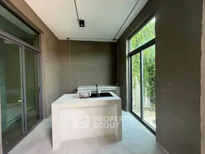Modern kitchen with sleek design and large windows offering natural light