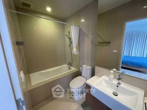 Modern bathroom with bathtub and sleek fixtures in a stylish apartment.