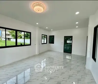 Spacious modern living room with elegant lighting and large windows.