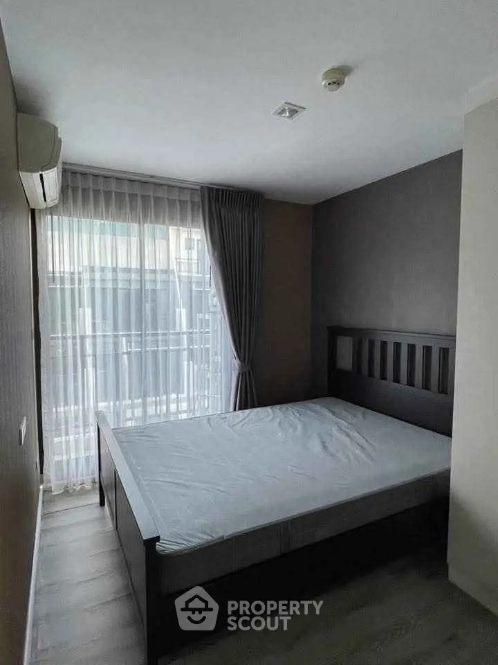 Modern bedroom with large window and minimalist decor in a stylish apartment.