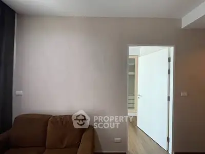 Cozy living room with brown sofa and open door to hallway