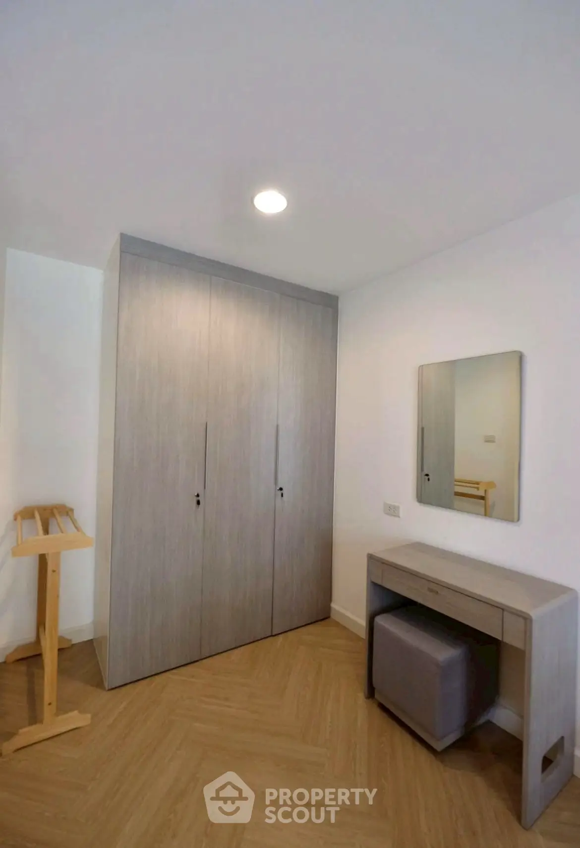 Modern bedroom with sleek wardrobe and stylish vanity in a cozy apartment.