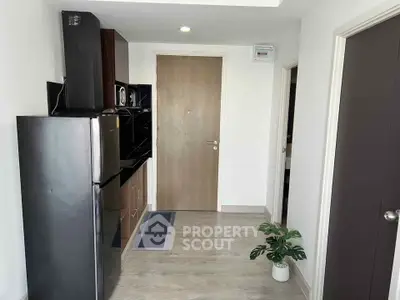 Modern kitchen with sleek appliances and minimalist design in a compact apartment.