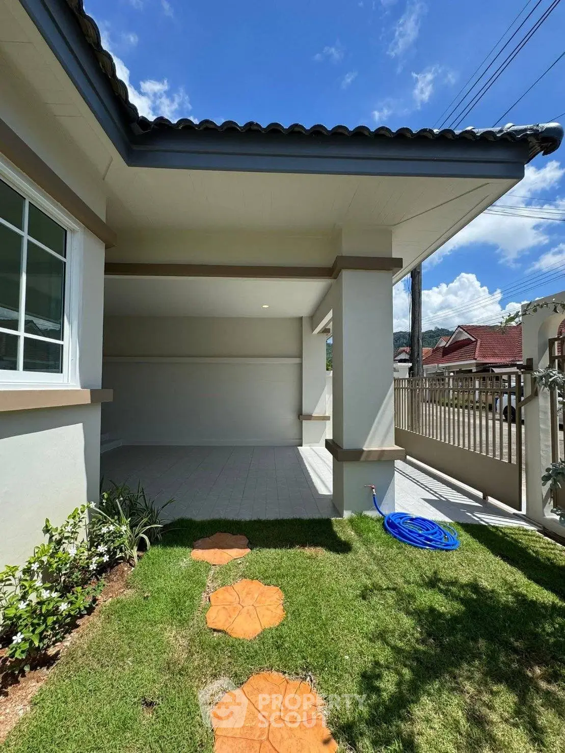Charming house exterior with spacious patio and lush garden, perfect for outdoor relaxation and entertaining.