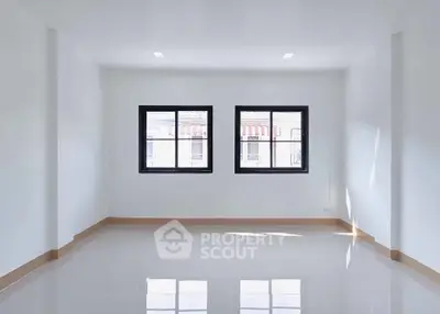 Spacious empty room with large windows and glossy tiled floor, perfect for customization.