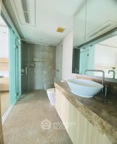 Luxurious modern bathroom with glass shower and elegant marble countertop.