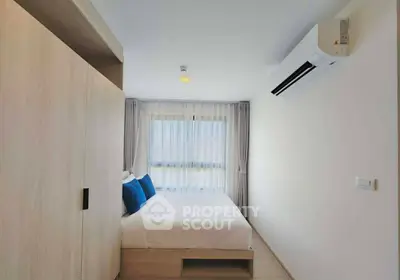 Modern bedroom with air conditioning and natural light, featuring a cozy bed and stylish decor.