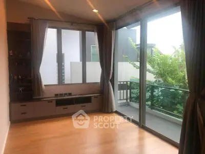 Spacious room with large windows and balcony access, perfect for natural light lovers.