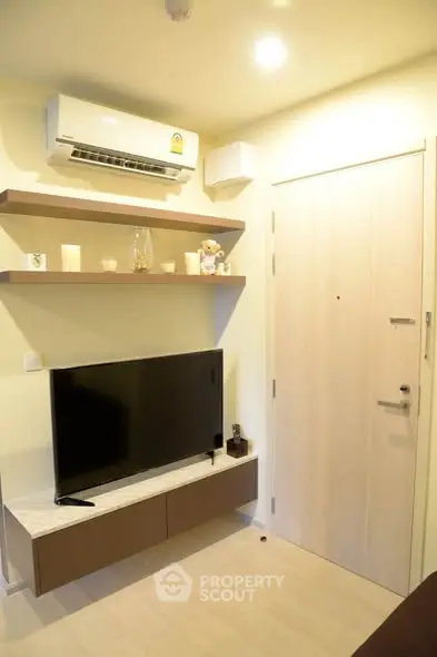 Modern living room with wall-mounted TV and air conditioning unit.