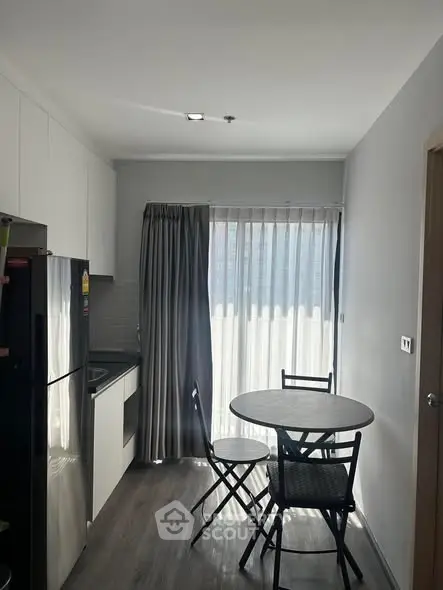 Modern kitchen with dining area and natural light in a stylish apartment.