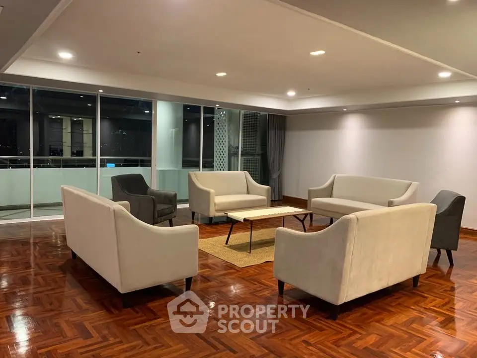 Spacious modern living room with elegant seating and polished wooden floors, perfect for relaxation and entertaining.