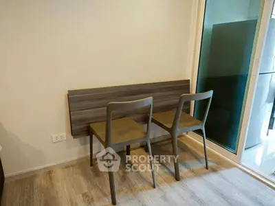 Modern dining nook with wooden chairs and sleek flooring in a cozy apartment.