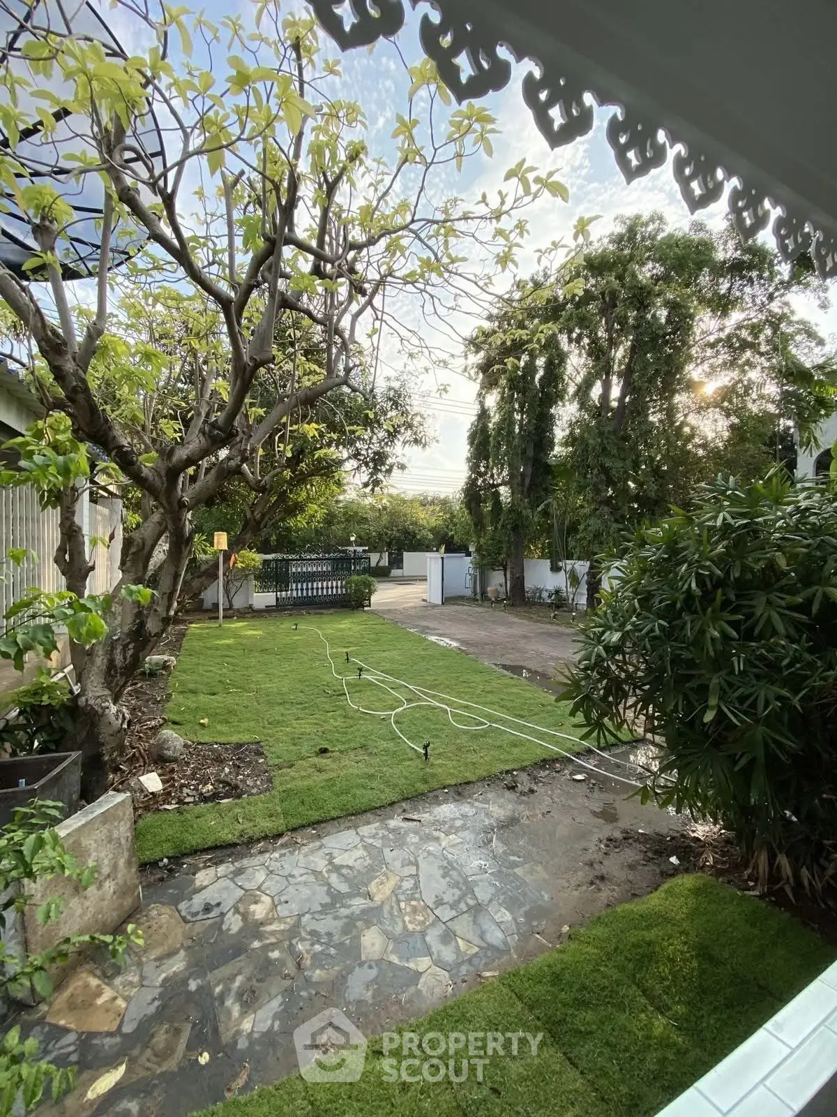 Charming garden view with lush greenery and stone pathway, perfect for serene outdoor living.
