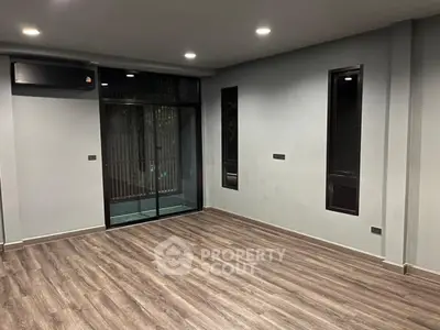 Spacious modern living room with wooden flooring and large windows