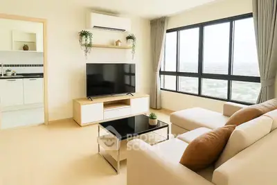 Modern living room with large window and stylish furniture, offering a bright and inviting atmosphere.