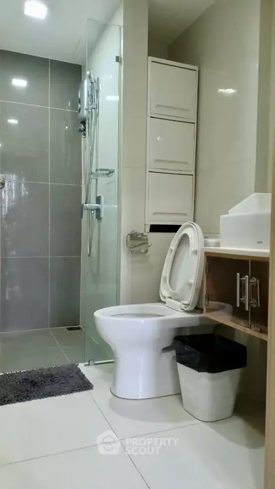 Modern bathroom with sleek design, featuring glass shower and contemporary fixtures.
