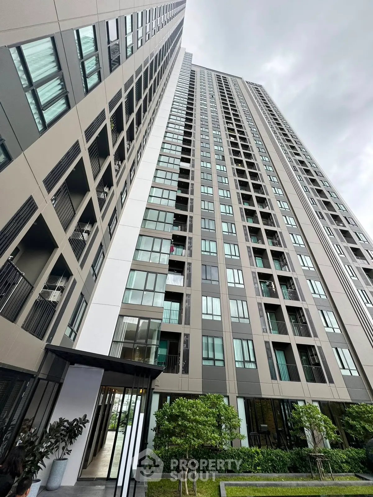 Modern high-rise building with sleek architecture and lush landscaping