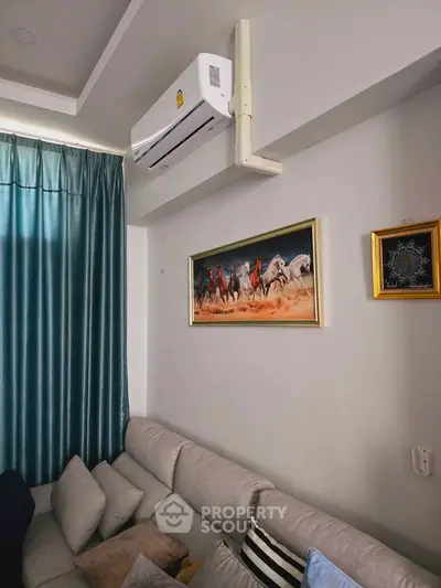Cozy living room with modern air conditioning and elegant wall art, featuring a comfortable sofa and stylish curtains.