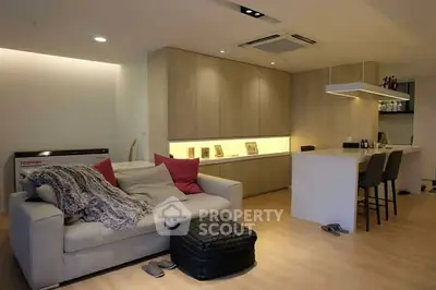 Modern living room with cozy sofa and sleek kitchen design