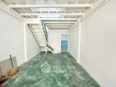 Spacious industrial-style interior with mezzanine and green flooring