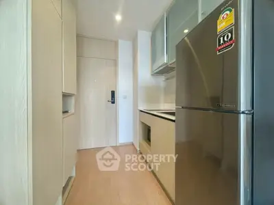 Modern kitchen with sleek cabinetry and stainless steel appliances in a compact layout.