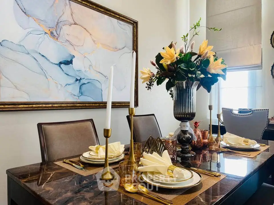 Elegant dining room with marble table, stylish decor, and modern art piece, perfect for sophisticated gatherings.