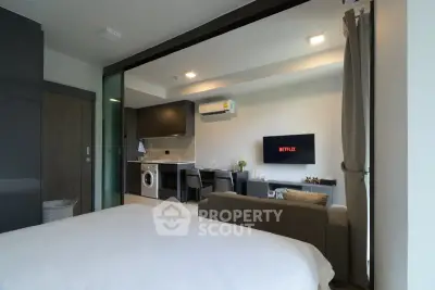 Modern studio apartment with open layout, featuring a cozy living area and sleek kitchen.