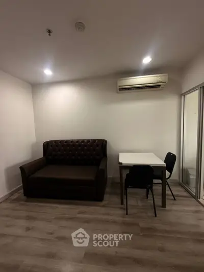 Cozy living room with sofa, table, and air conditioning in modern apartment.