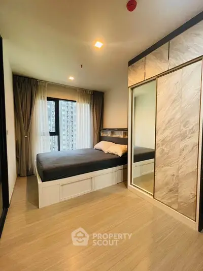 Modern bedroom with large window and stylish wardrobe in urban apartment