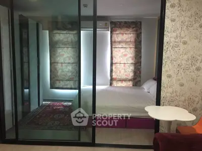 Modern bedroom with glass partition and stylish decor in a cozy apartment.