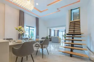 Luxurious open-plan living and dining area with elegant staircase and modern decor.