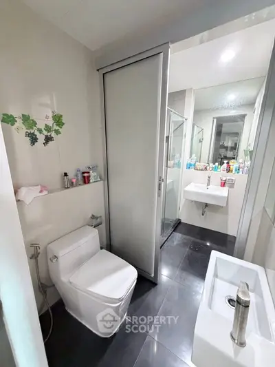 Modern bathroom with sleek fixtures and sliding door for privacy