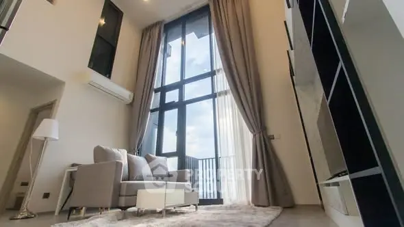 Spacious living room with floor-to-ceiling windows and elegant decor