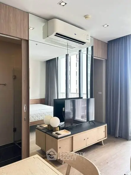 Modern apartment interior with sleek design, featuring a cozy living area and a glimpse of the bedroom.