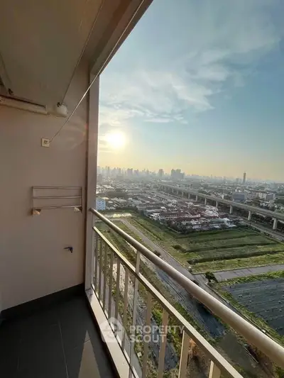 Stunning high-rise balcony view with cityscape and sunset, perfect for urban living enthusiasts.