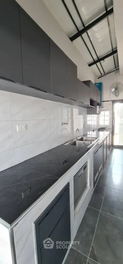Modern kitchen with sleek black cabinetry and marble countertops