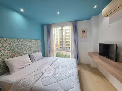 Modern bedroom with blue accents and city view, featuring a cozy bed and wall-mounted TV.