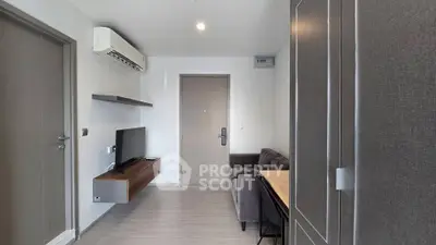 Modern living room with sleek design, featuring a wall-mounted TV and air conditioning unit.