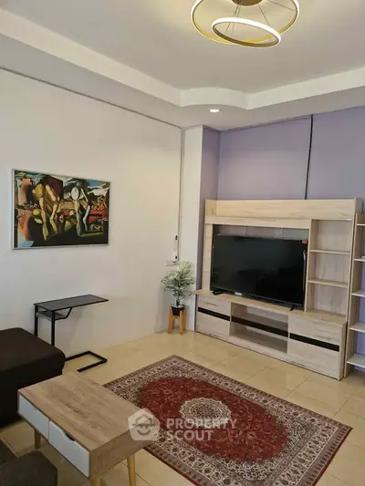Modern living room with stylish furniture and large TV unit, perfect for relaxation.