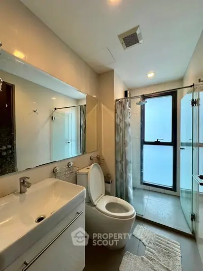 Modern bathroom with glass shower and sleek fixtures in a contemporary apartment.
