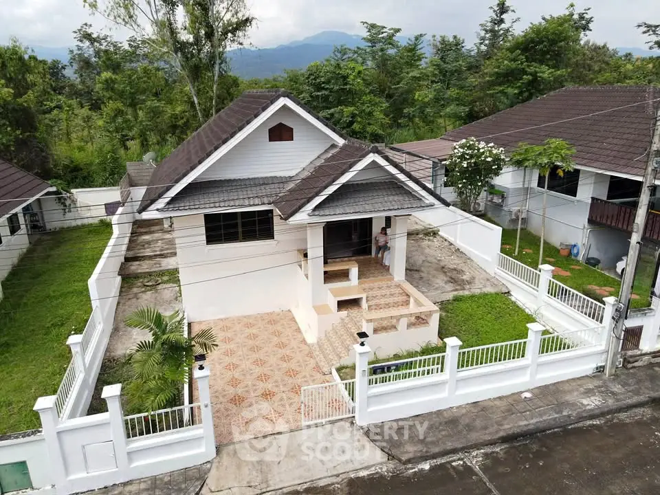 Charming single-story house with tiled patio and lush greenery in a serene neighborhood.