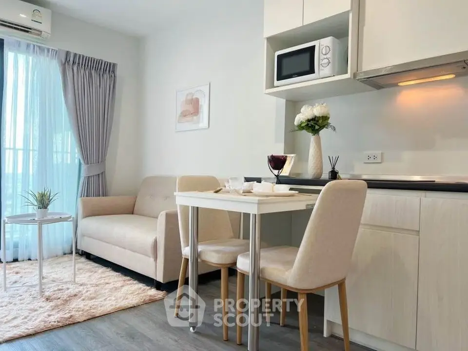 Modern living room with cozy dining area and stylish kitchen in open layout apartment.