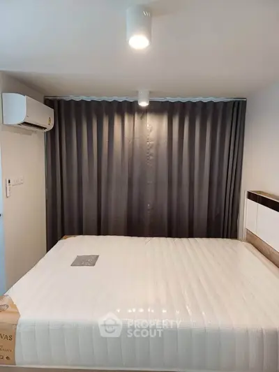 Cozy bedroom with modern lighting and air conditioning, featuring a comfortable bed and stylish curtains.
